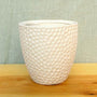 small fingerprint-sized indents decorating a matte white ceramic finish