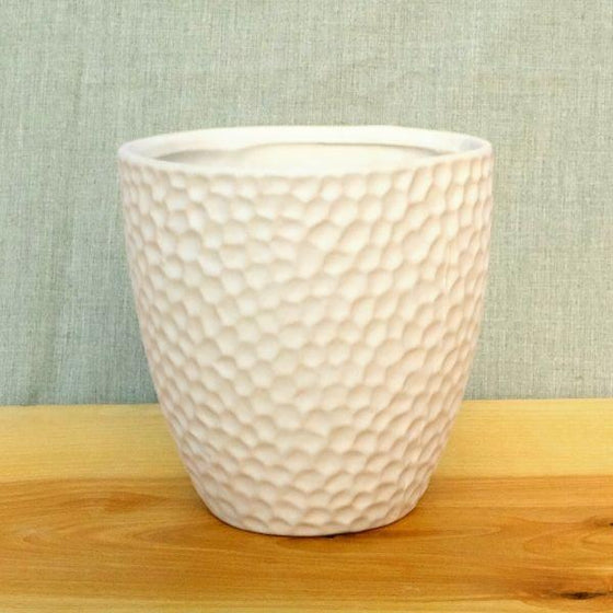 small fingerprint-sized indents decorating a matte white ceramic finish